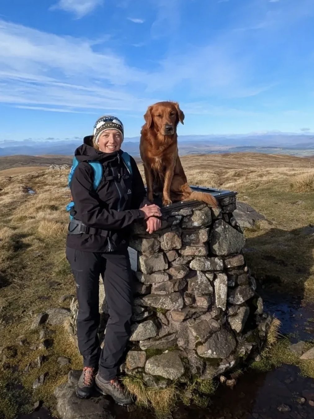 Menucha Knebel on a hilltop with her Golden Retriever