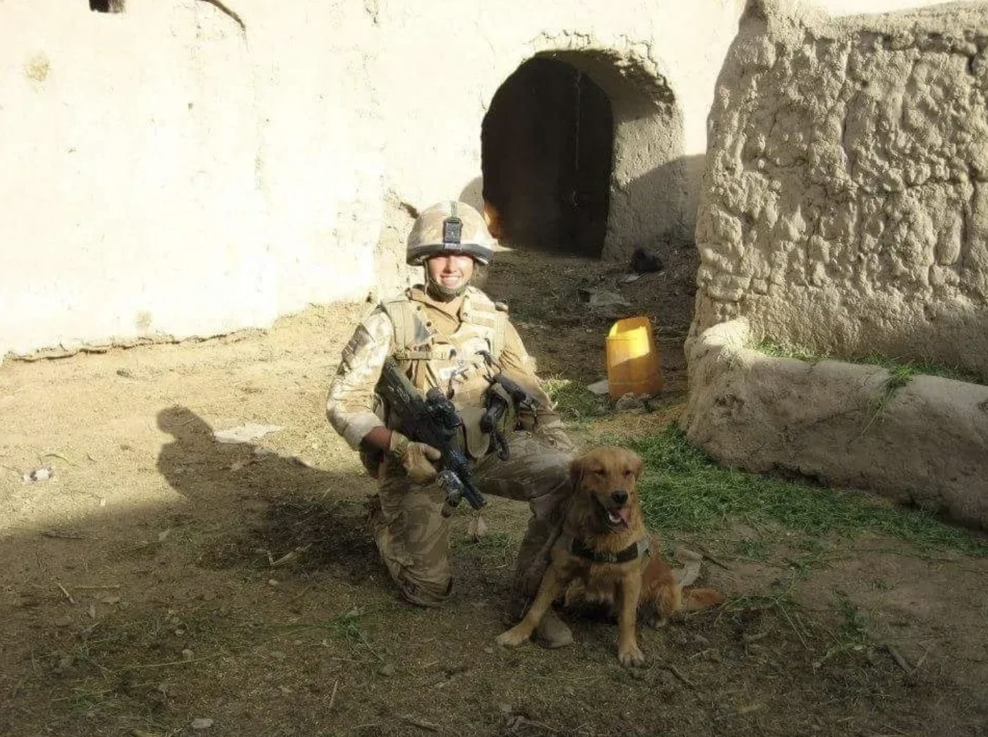 Menucha during her military service, kneeling beside a working dog